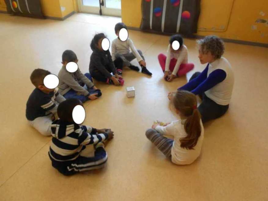 L'insegnante seduta in cerchio con i bambini.